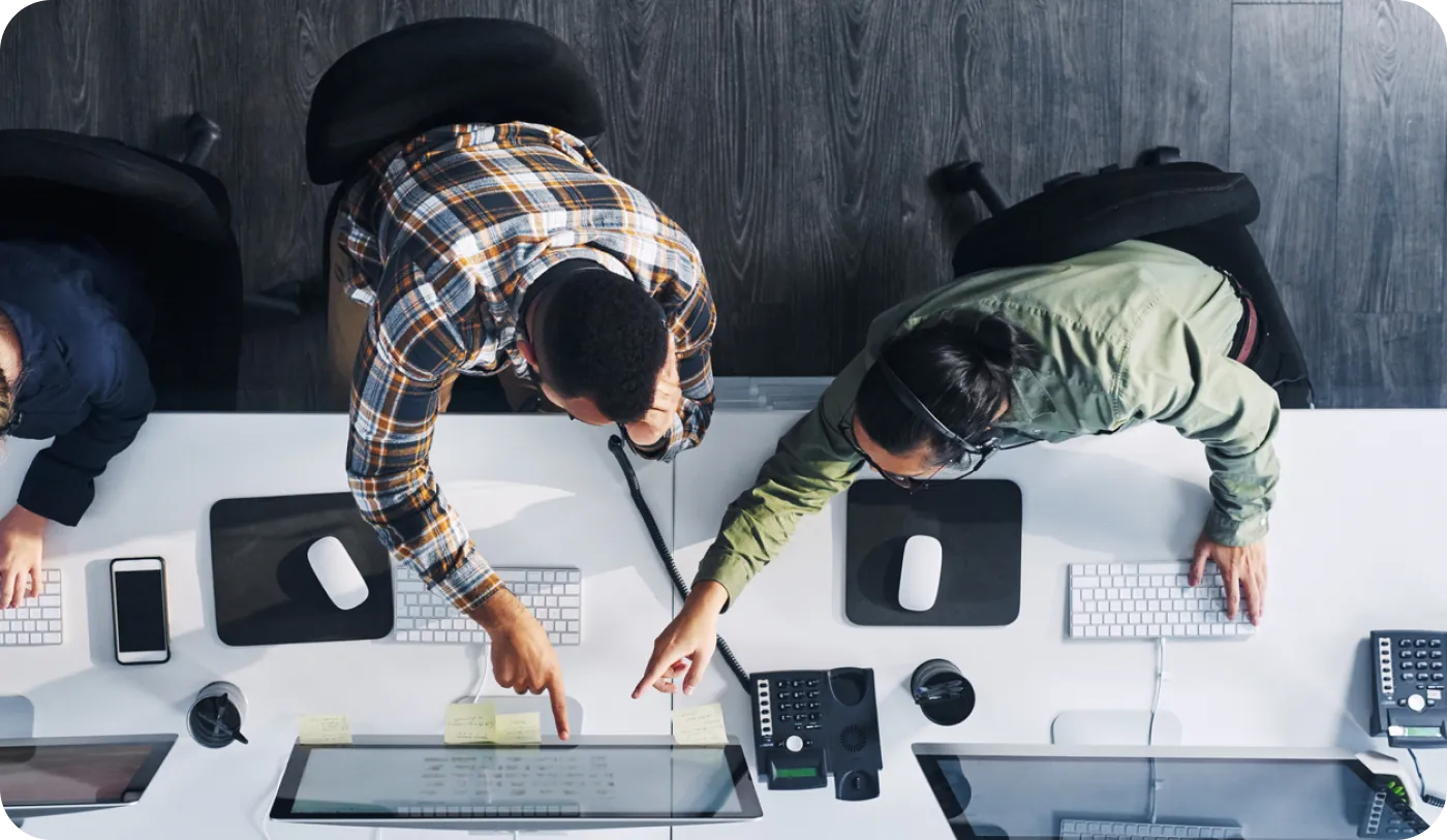 Team collaborating at desks with monitors