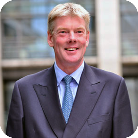 Professional team member in a suit and tie, pictured outdoors in a corporate setting.